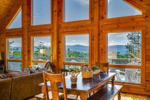 een woonkamer met een tafel en een aantal ramen bij Hot Tub Epic View Fire Pit 40 Acres in Old Fields +61 foto's