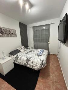 ein Schlafzimmer mit einem Bett und einem Flachbildfernseher in der Unterkunft Casa Alegría in Cómpeta