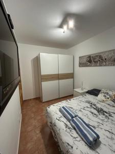 ein Schlafzimmer mit einem Bett und einem Flachbildfernseher in der Unterkunft Casa Alegría in Cómpeta + 8 Fotos