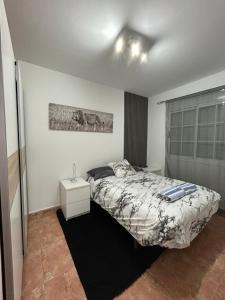 ein Schlafzimmer mit einem Bett und einem Nachttisch darin in der Unterkunft Casa Alegría in Cómpeta