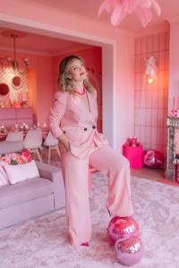 a woman in a pink suit standing in a room at The Rozette Experience in Ostend