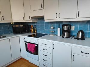 a kitchen with white cabinets and a stove top oven at Spacious Apartment in Kallio in Helsinki +3 photos