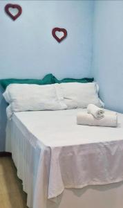 a bed with two towels on it with hearts on the wall at Aconchego IV in Miguel Pereira