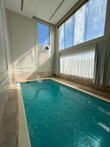 a swimming pool in a home with a large window at شاليه كادي cady resort in Al Khobar