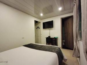 um quarto com uma cama e uma TV de tela plana em C habitación con baño privado em Bogotá mais 7 fotografias