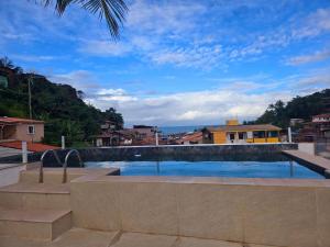 a swimming pool with a view of the ocean at Apartamento Gute Morro - Praça Central in Cairu