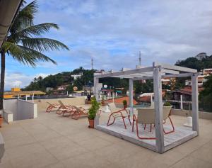 a group of chairs and tables on a roof at Apartamento Gute Morro - Praça Central in Cairu +16 photos