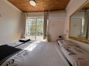 una camera da letto con un letto con uno specchio e una finestra di Kasa R a Herzelia