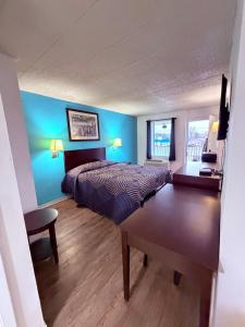a bedroom with a bed and a blue wall at Executive Inn Coopersburg in Coopersburg