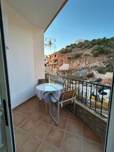 ein Balkon mit Tisch und Blick auf eine Stadt in der Unterkunft Casa Alegría in Cómpeta