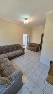 a living room with couches and a tile floor at Residencial Ana Jacinta in Campinas