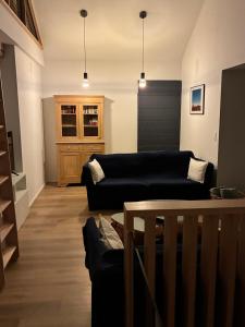 ein Wohnzimmer mit zwei schwarzen Sofas und einem Tisch in der Unterkunft Gite Chez Mamy Pol autour du lac de la Gileppe in Jalhay