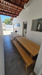 a group of wooden tables on a patio at Residencial Ana Jacinta in Campinas
