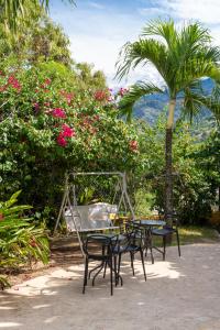 a table and chairs with a palm tree and flowers at Encomendero Hotel -Centro Histórico- in Santa Fe de Antioquia