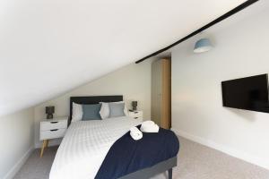 a bedroom with a bed and a flat screen tv at Large 4-Bedroom House in Banbury in Banbury