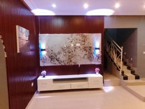 a living room with a large fish tank on a wall at Cutting Edge Guest House in Daranka