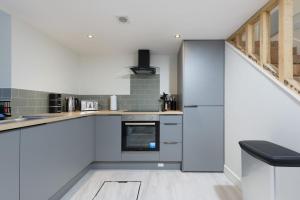 a kitchen with white cabinets and a staircase at Large 4-Bedroom House in Banbury in Banbury