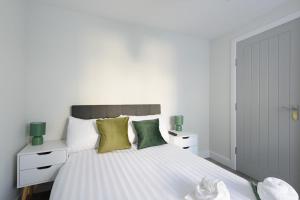 a bedroom with a large white bed with green pillows at Large 4-Bedroom House in Banbury in Banbury +14 photos