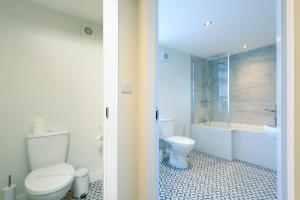 a bathroom with a toilet and a tub and a sink at Large 4-Bedroom House in Banbury in Banbury