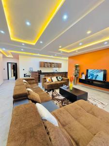 una gran sala de estar con sofás y TV de pantalla plana. en StayatMargarets, en Abuja 21 fotos más