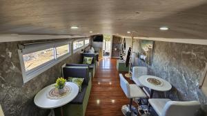 einen Innenblick auf einen Wohnwagen mit Tischen und Stühlen in der Unterkunft Bird Bus Chile - Descanso- Aventura - Comodidad in Chillán