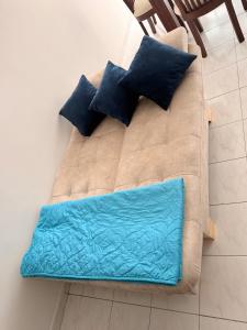 un divano marrone con cuscini blu sopra di Apartamento frente al parque infantil a Pasto