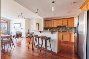 a kitchen with a refrigerator and a table and chairs at El Paraiso - Luxury Downtown Penthouse in Canmore