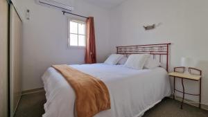 a bedroom with a large white bed with a window at La Maisonnette du Soleil in Gallargues-Le-Montueux +43 photos