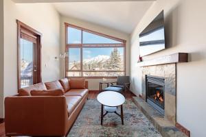 a living room with a couch and a fireplace at El Paraiso - Luxury Downtown Penthouse in Canmore