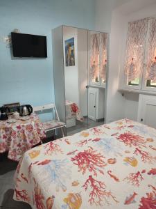 卡莫利Affittacamere Ancora的一间卧室，墙上有一张床和一台电视