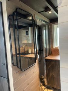 eine Küche in einem winzigen Haus mit einem Spiegel in der Unterkunft Tiny house on wheels with great views Sjusjøen in Mesnali