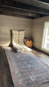 eine Couch in der Ecke eines Zimmers mit einem Teppich in der Unterkunft Tiny house on wheels with great views Sjusjøen in Mesnali + 12 Fotos