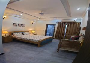 una grande camera da letto con un letto e una sedia di Giga Apartments & Sapphire Suite a Rawalpindi
