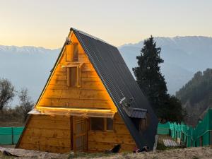 a small wooden cabin with a pitched roof at Crystal peak cottage in Nagar