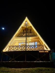 纳加尔Crystal peak cottage的夜晚，一座茅草屋顶的大木屋