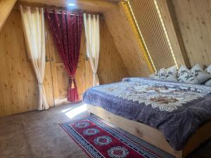 纳加尔Crystal peak cottage的一间带床的卧室，位于一间带木墙的房间里