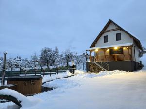 a house covered in snow with lights on it at Chata Závažka in Závažná Poruba