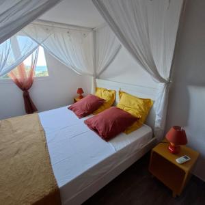 a bedroom with a bed with red and yellow pillows at Oasis Grande Anse in Deshaies +89 photos