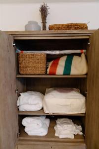 ein hölzerner Schrank mit Handtüchern, Körben und Handtüchern in der Unterkunft Boxwood Haven in Moscow