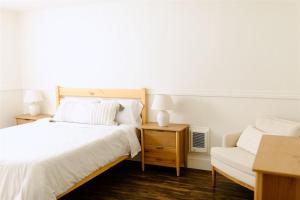 ein Schlafzimmer mit zwei Betten und einem Stuhl in der Unterkunft Boxwood Haven in Moscow