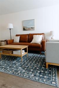 ein Wohnzimmer mit einem braunen Sofa und einem Couchtisch in der Unterkunft Boxwood Haven in Moscow