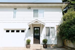 ein weißes Haus mit einer weißen Tür und Fenstern in der Unterkunft Boxwood Haven in Moscow