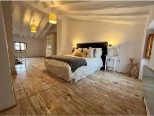 a bedroom with a large bed and a wooden floor at Halona Casa Rural in Bullas