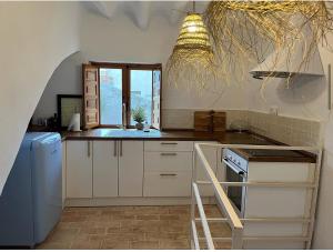 a kitchen with white cabinets and a sink and a window at Halona Casa Rural in Bullas