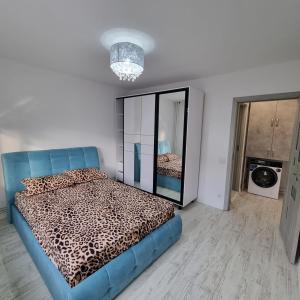 a bedroom with a blue bed and a mirror at Ploiesti Central Apartament in Ploieşti