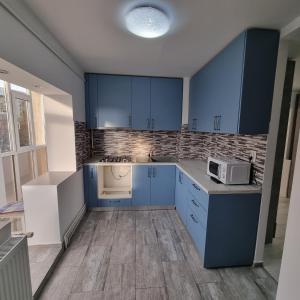 a kitchen with blue cabinets and a microwave at Ploiesti Central Apartament in Ploieşti