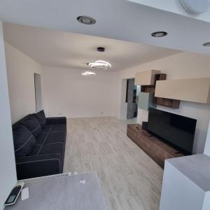 a living room with a couch and a flat screen tv at Ploiesti Central Apartament in Ploieşti