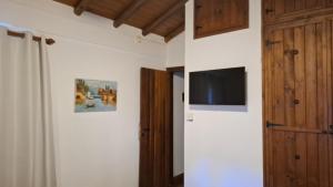 a room with a door and a television on a wall at Cabañas lodge El Suizo in Gobernador Virasora