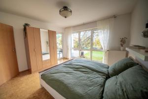 ein Schlafzimmer mit einem großen Bett und einem großen Fenster in der Unterkunft Am Feigenbaum in Albisheim