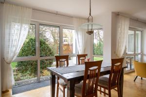 ein Esszimmer mit Tisch und Stühlen und großen Fenstern in der Unterkunft Am Feigenbaum in Albisheim
